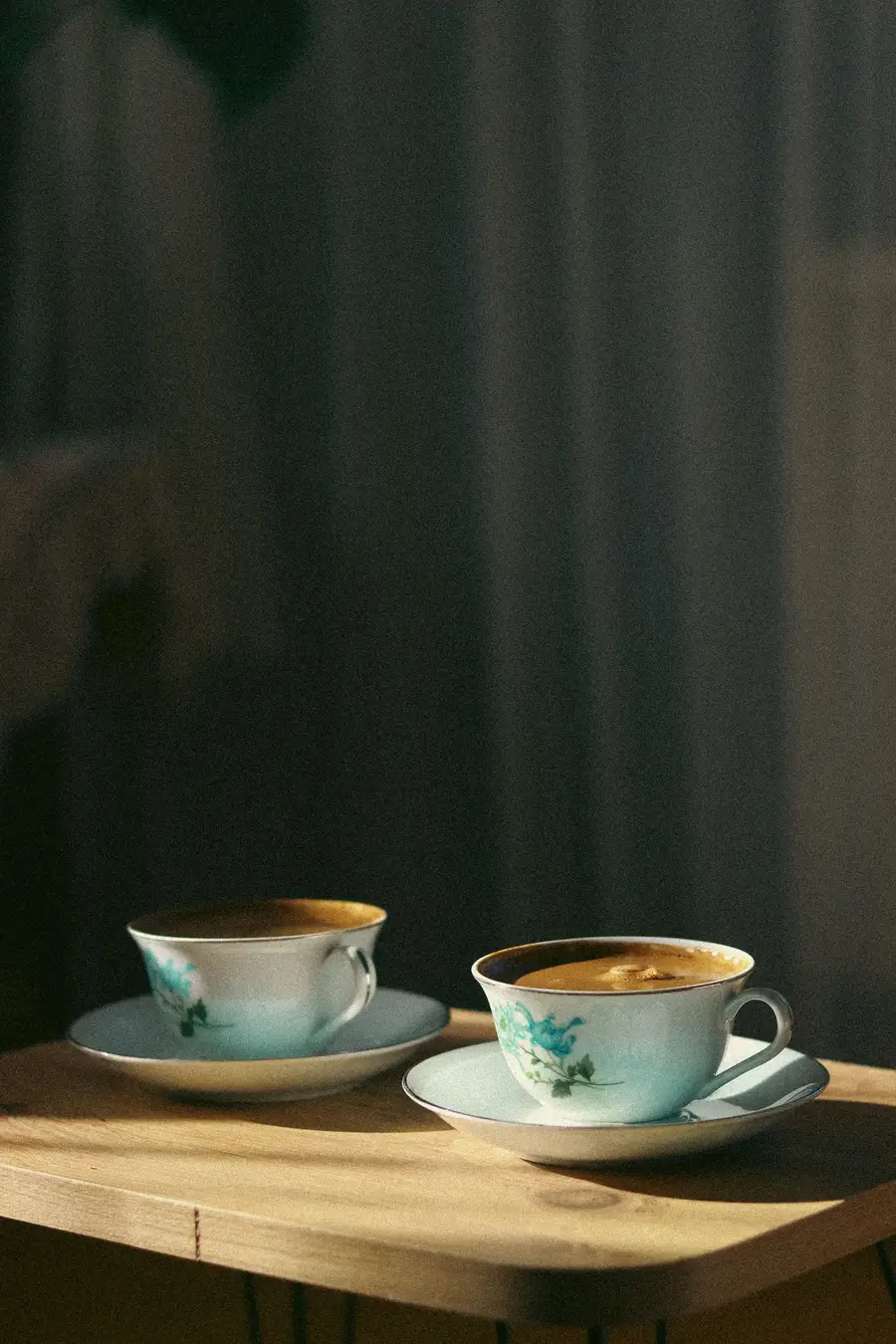 Zwei Kaffeetassen und ein Notizbuch auf einem Holztisch